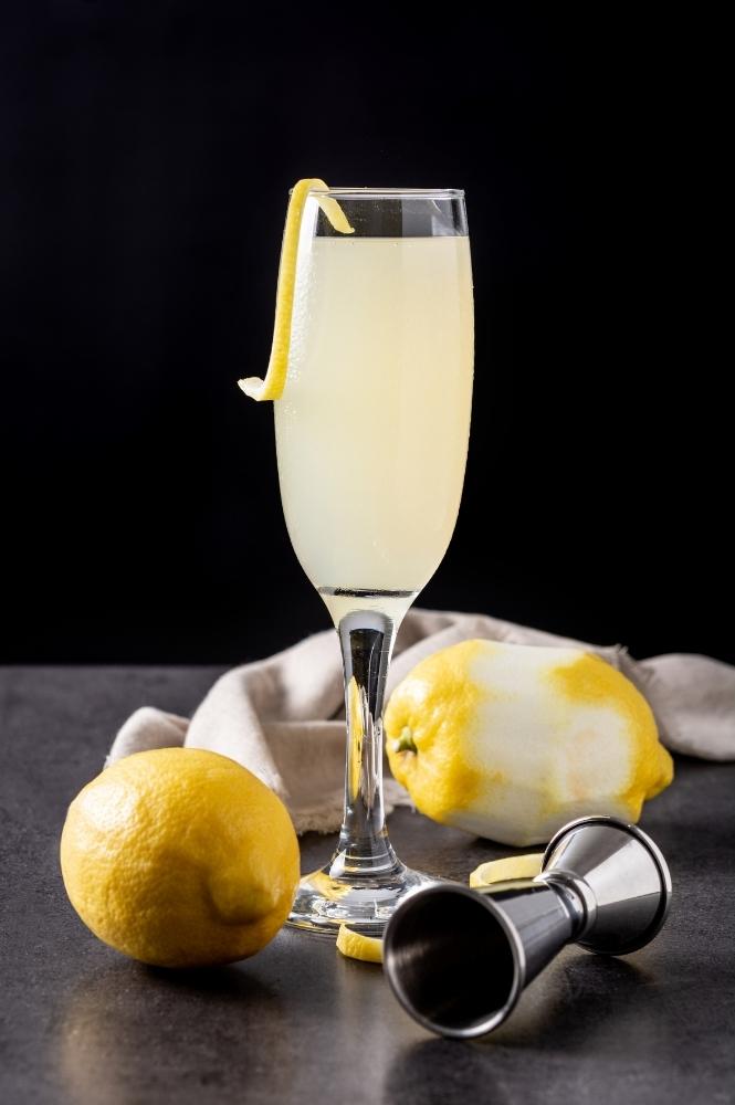Single French 76 Cocktail with Lemons and Drink Jigger for Recipe