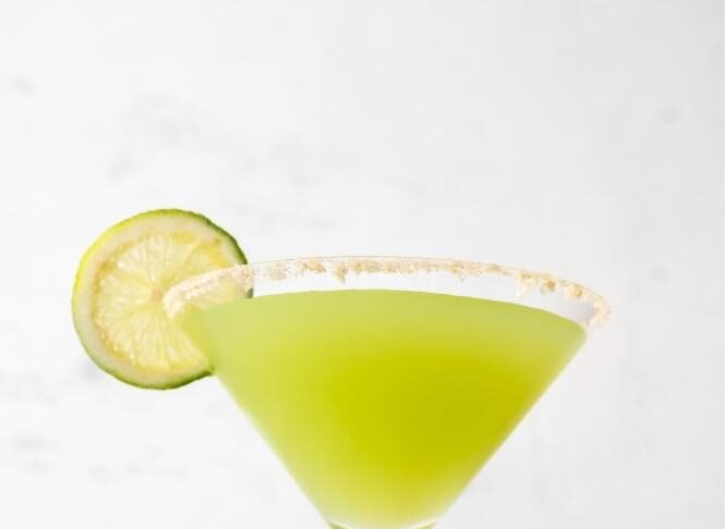 Glass of Key Lime Pie Martini Cocktail Garnished with Key Lime Wheel