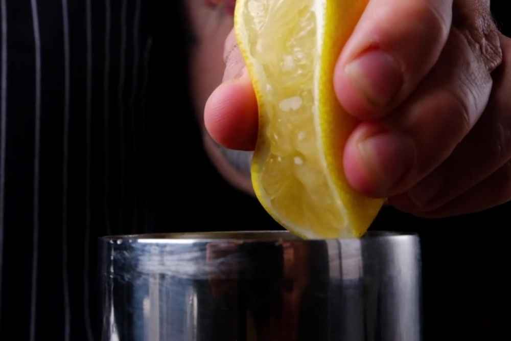 Squeezing Fresh Lemon Juice into White Tea Shot Cocktail