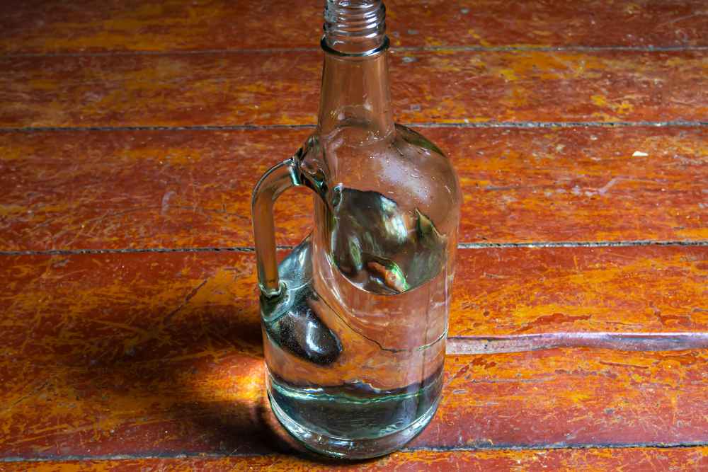 Handle of Vodka Open Glass Bottle on Wood