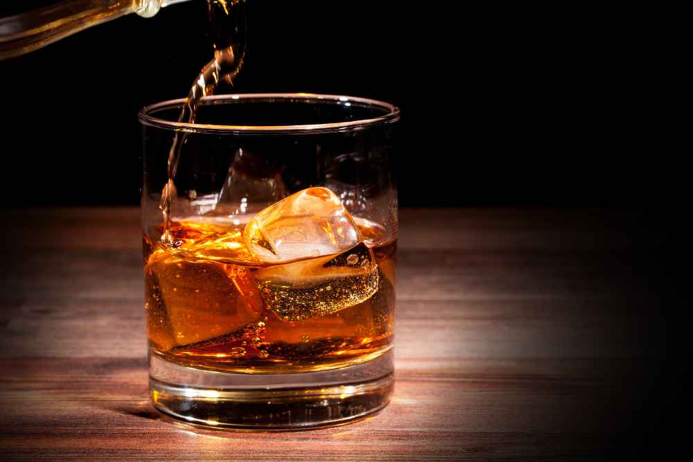 Pouring Whiskey into Rocks Glass with Ice