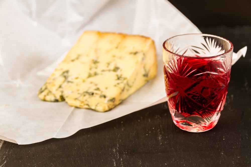 Glass of Sloe Gin with a Wedge of Cheese